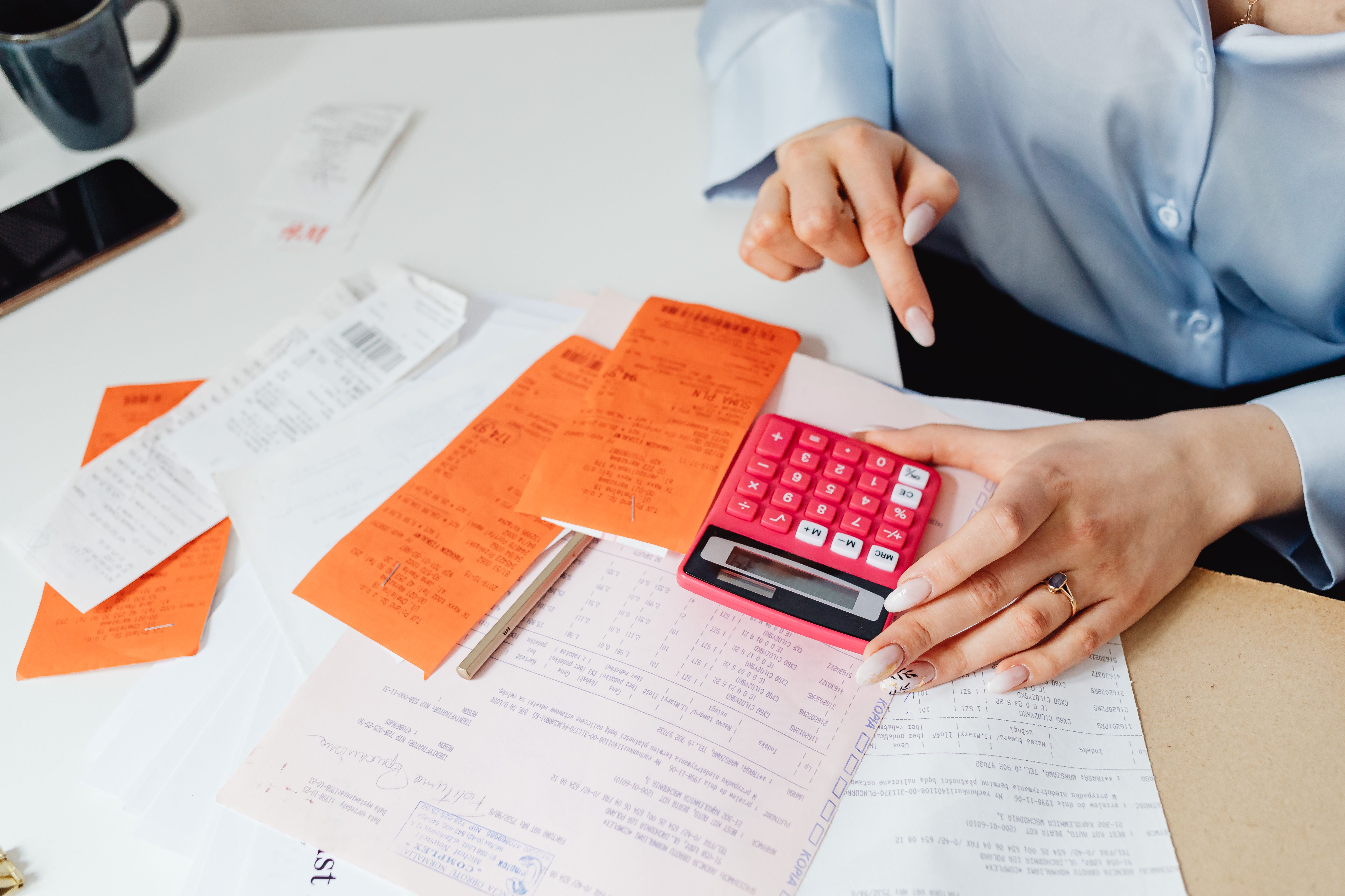 Businesswoman reviewing receipts and calculating expenses at a desk