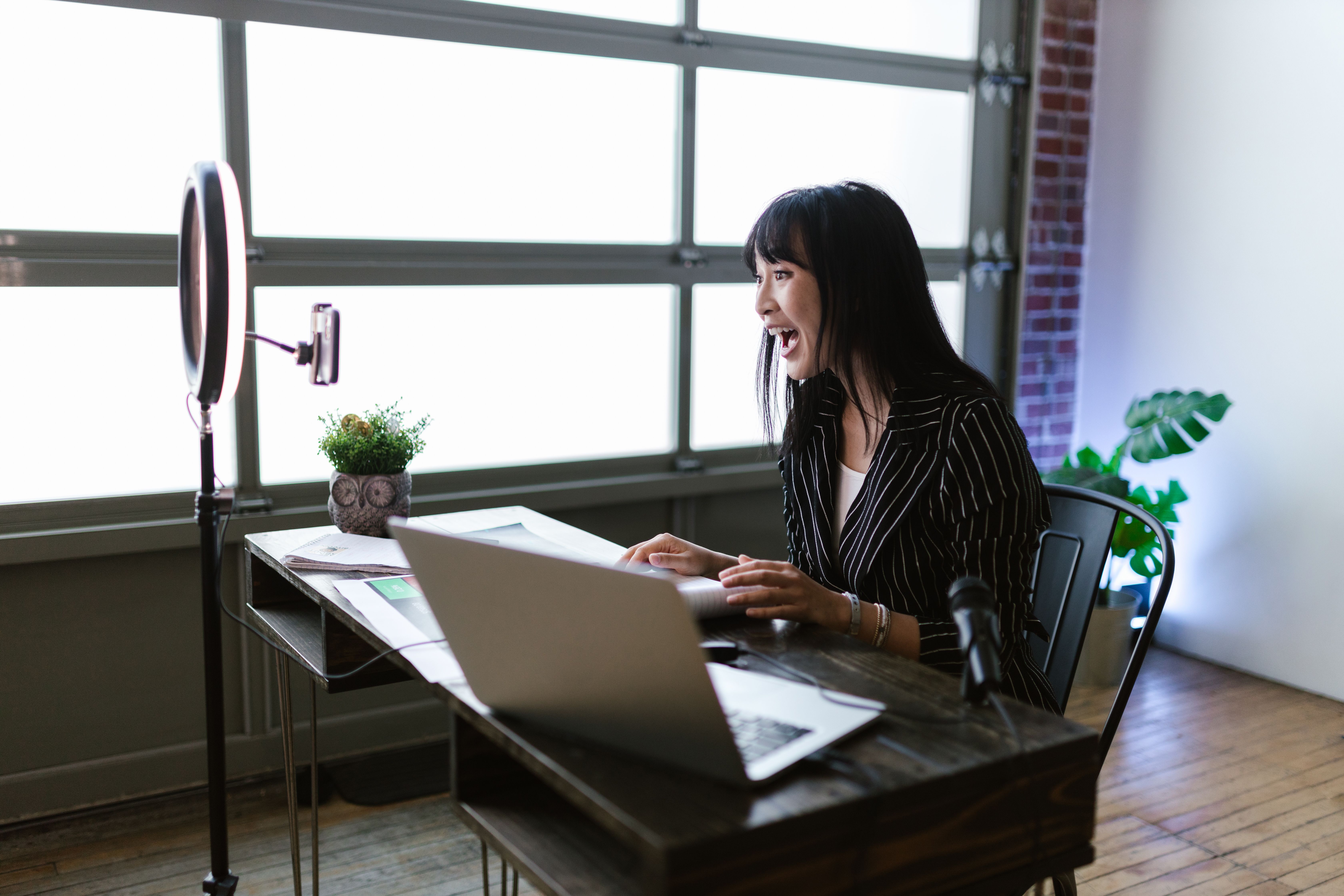 A creator records digital content with a laptop and ring light, reflecting the shift toward independent online platforms.