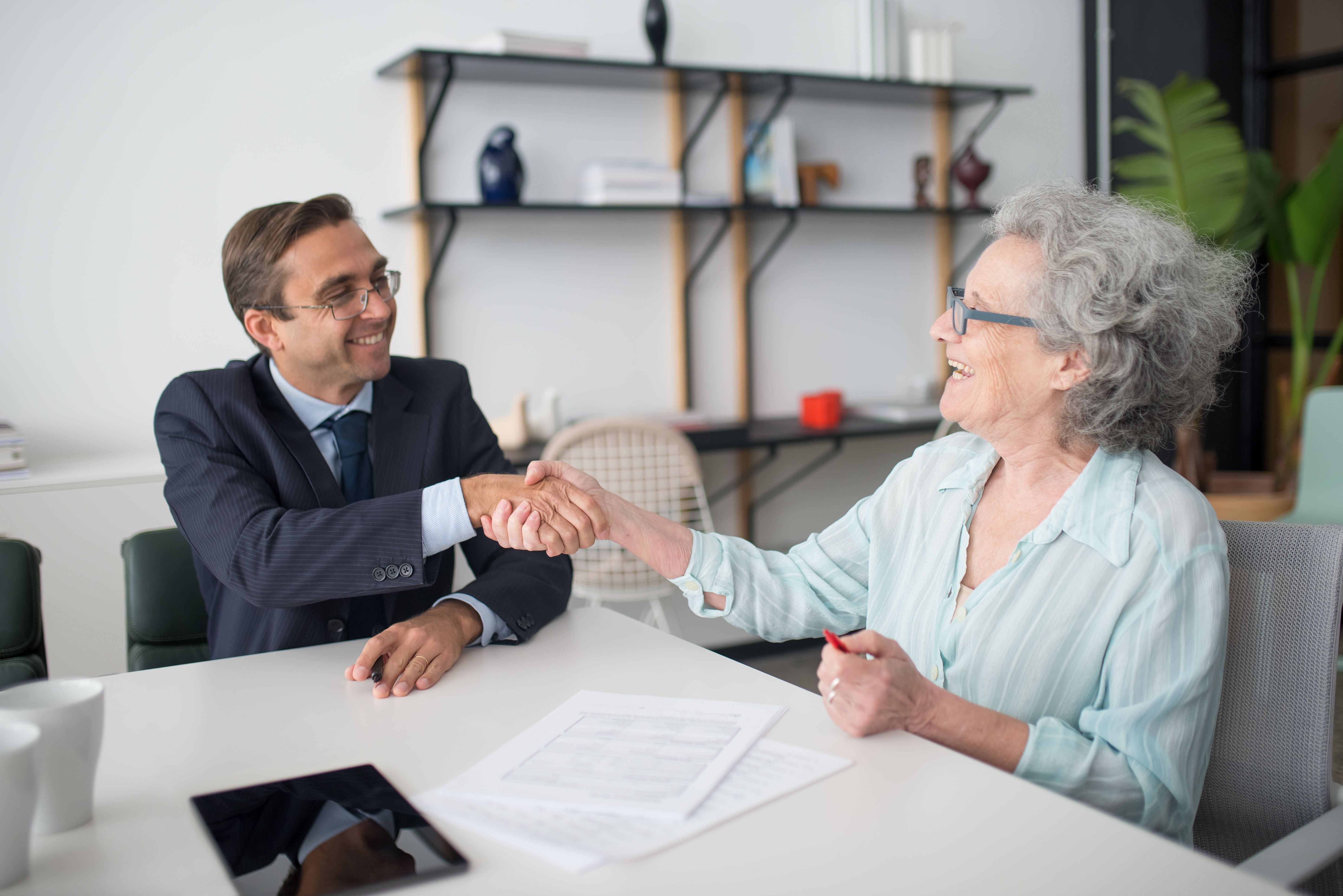 Business consultant and client shaking hands over a funding agreement for legal fees