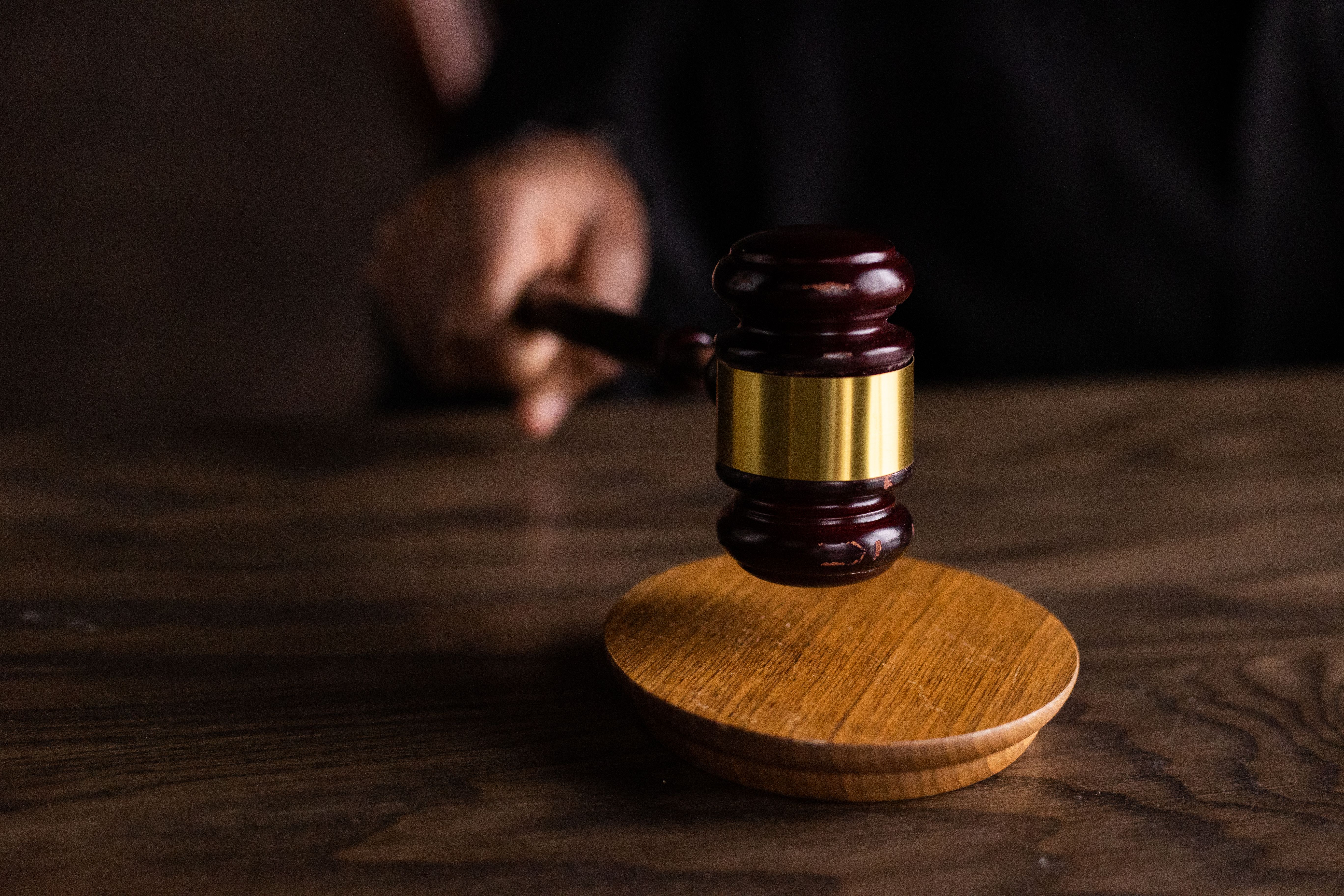 Gavel striking a sound block in a courtroom symbolizing a drawn-out legal trial