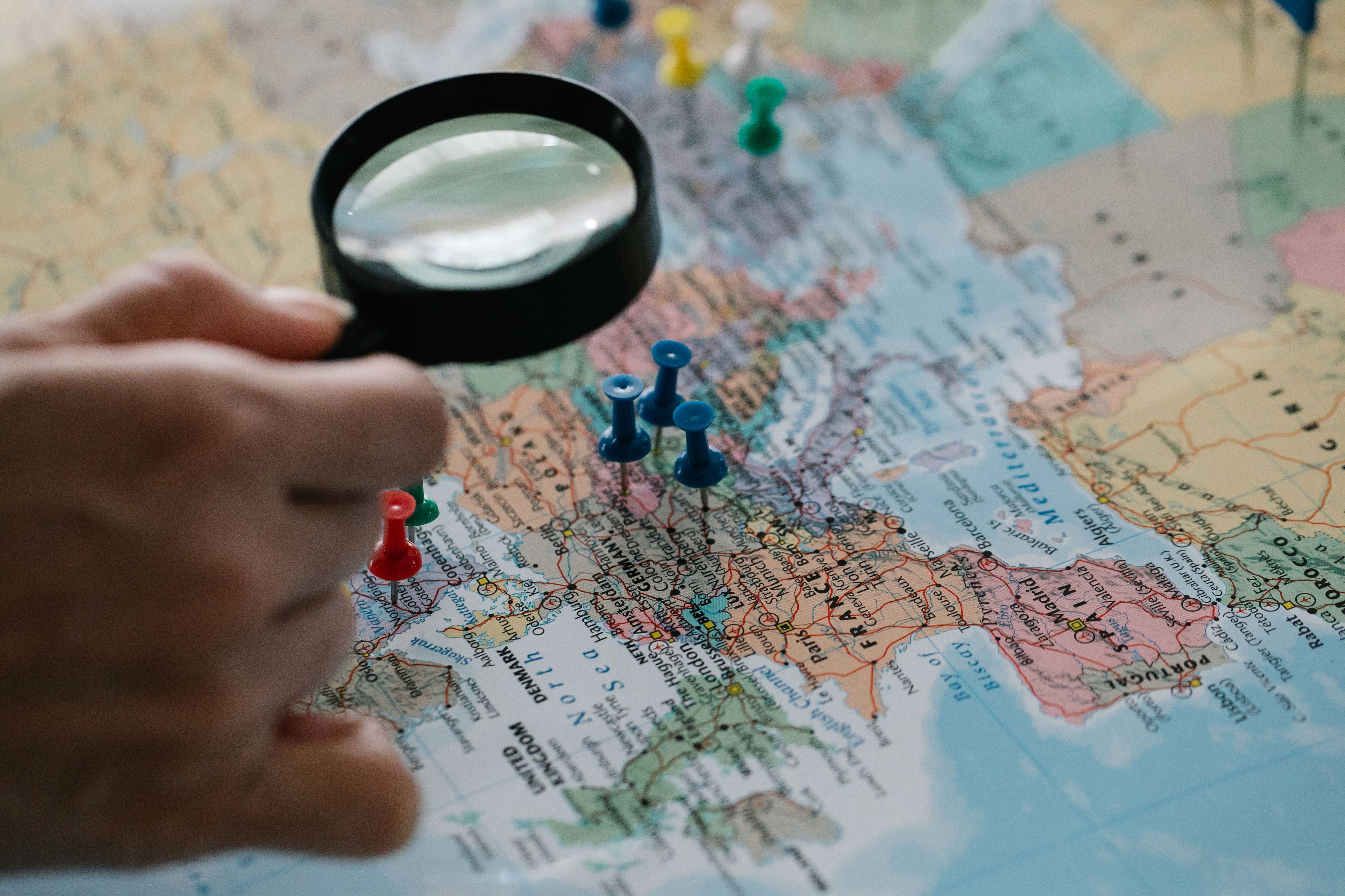 Magnifying glass highlighting locations on a world map