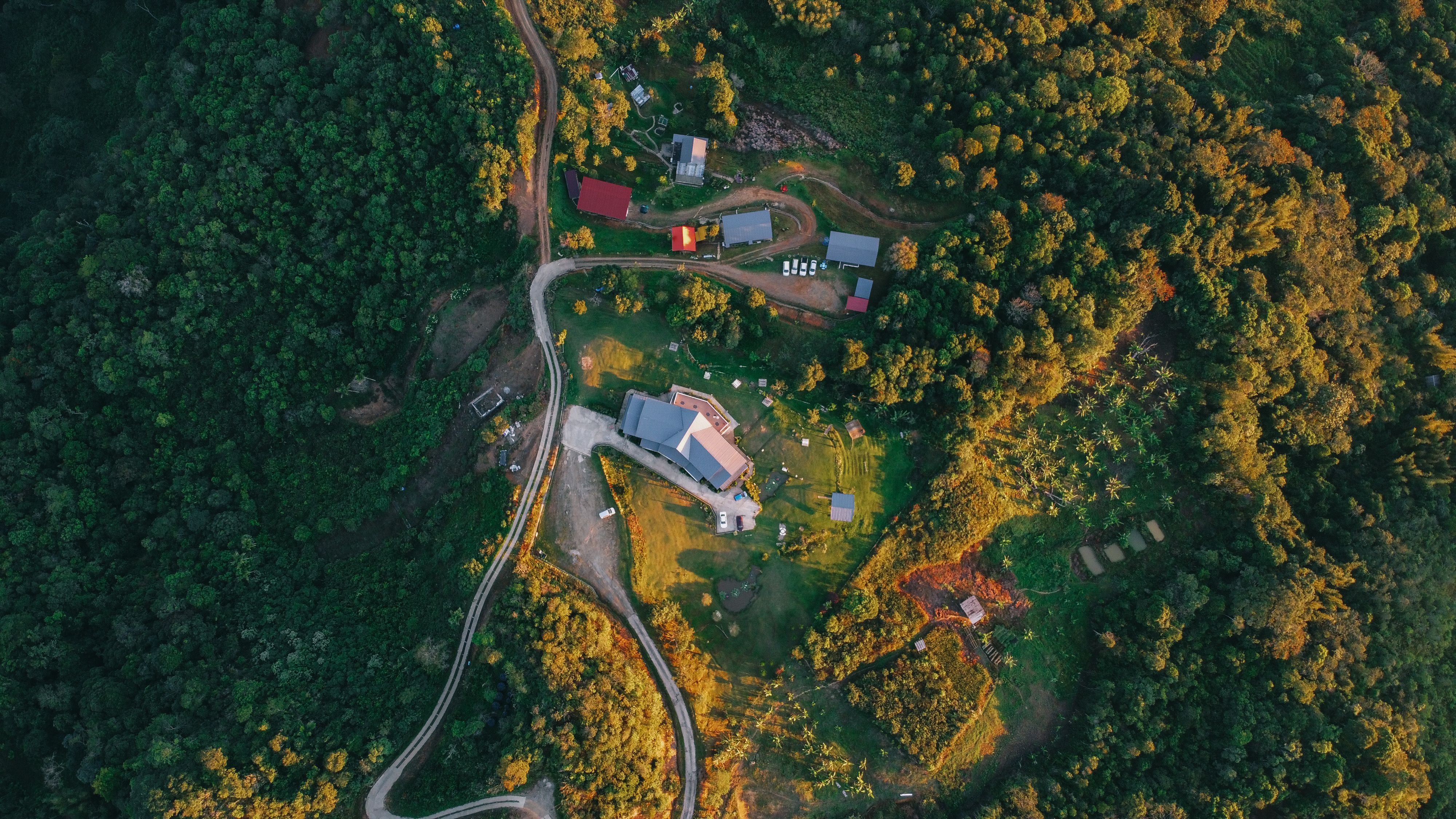 Aerial view of a rural village surrounded by greenery in Kundasang, Sabah, highlighting rural communities and development needs.