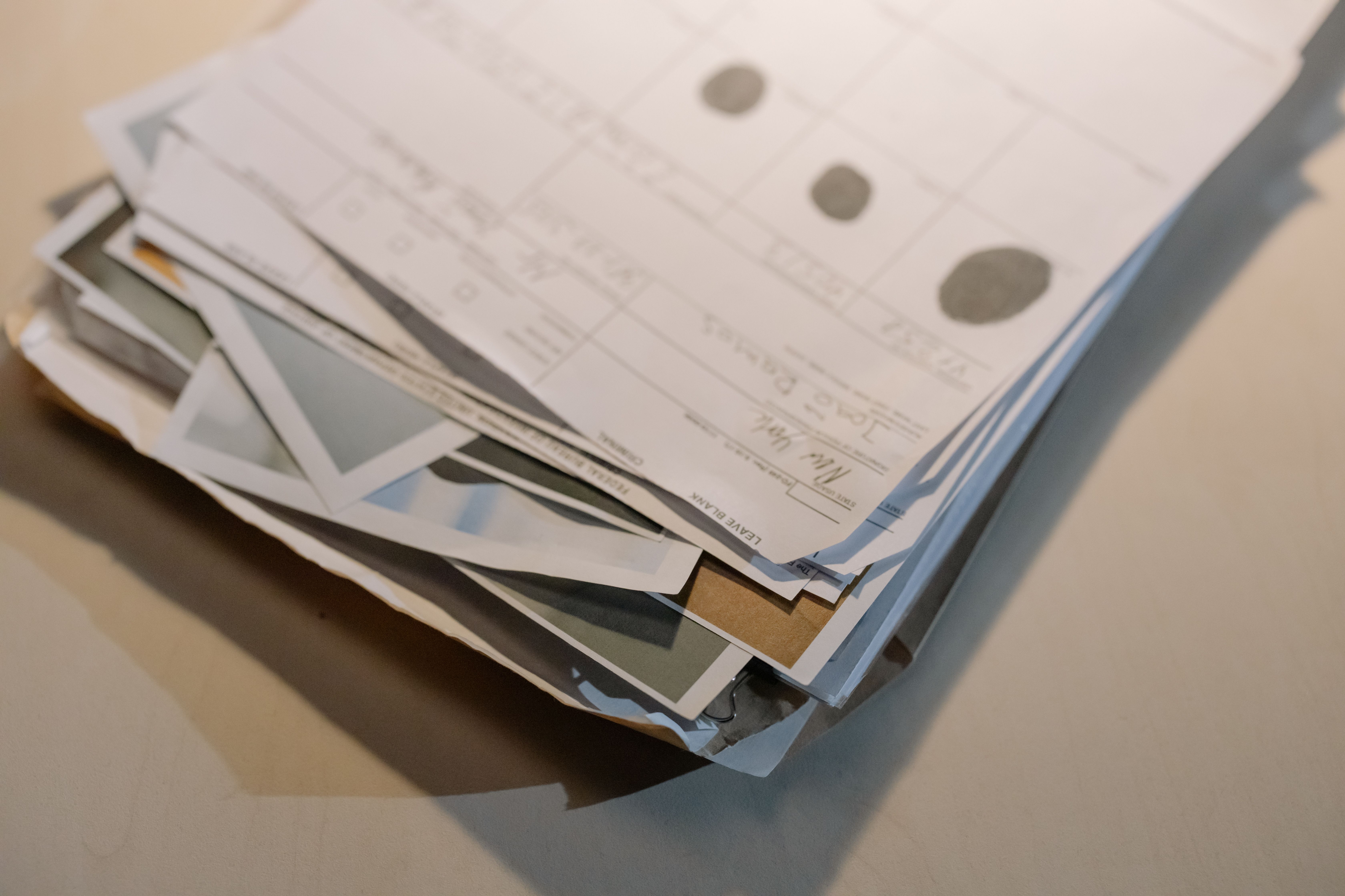 Stack of legal documents and case files piled on a desk from a long-running lawsuit