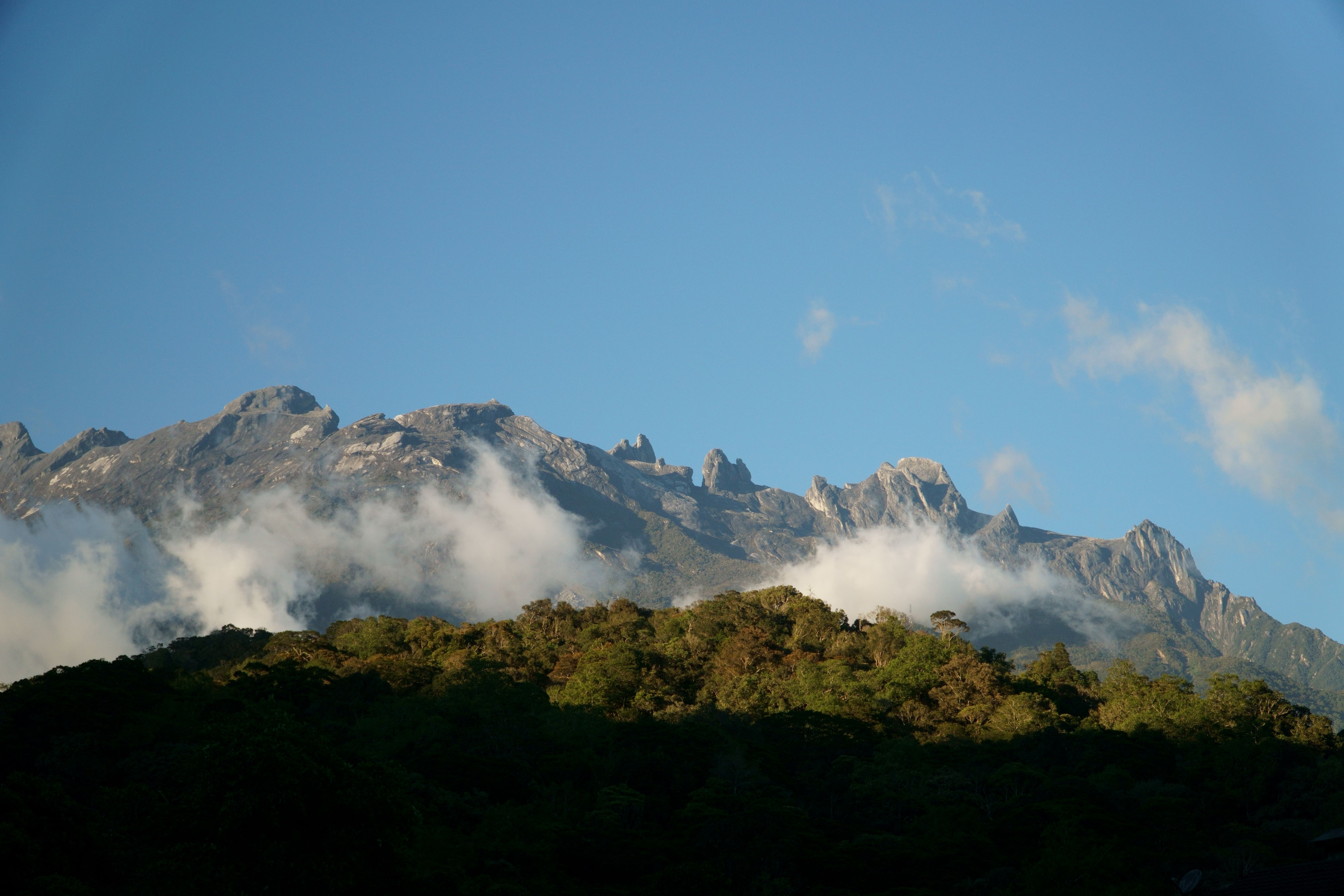 Mount Kinabalu rising above Sabah's lush forest landscape, representing the state's natural assets and tourism economy.